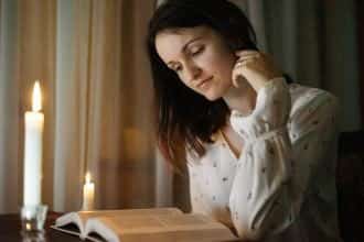 Woman reading by candle light